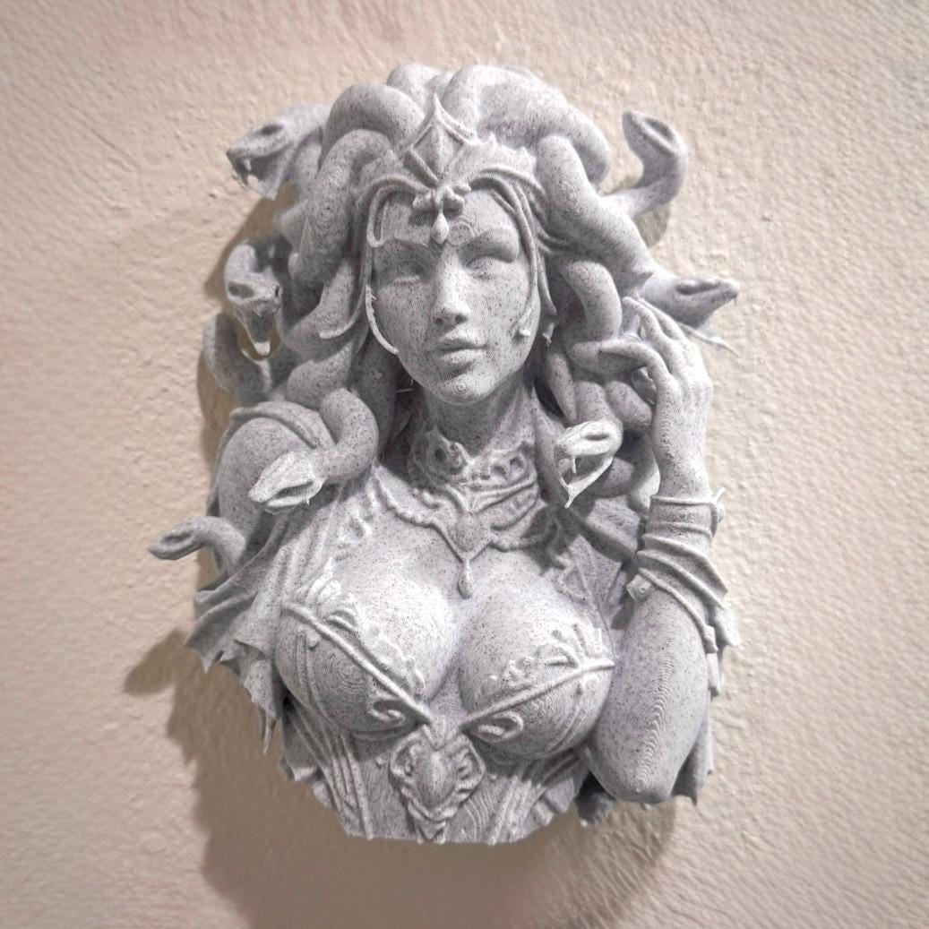Front view of stone-look Medusa wall bust with snake hair and sculpted armor