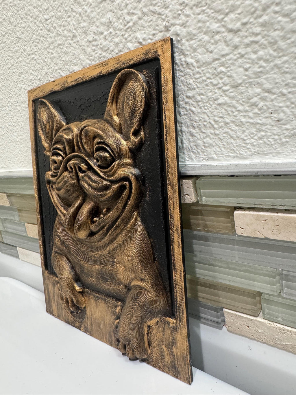 Left angle of the French Bulldog plaque leaning on a backsplash