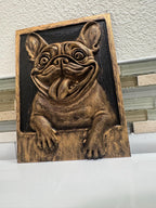 Slight angle of the gold and black bulldog plaque with paws on the ledge