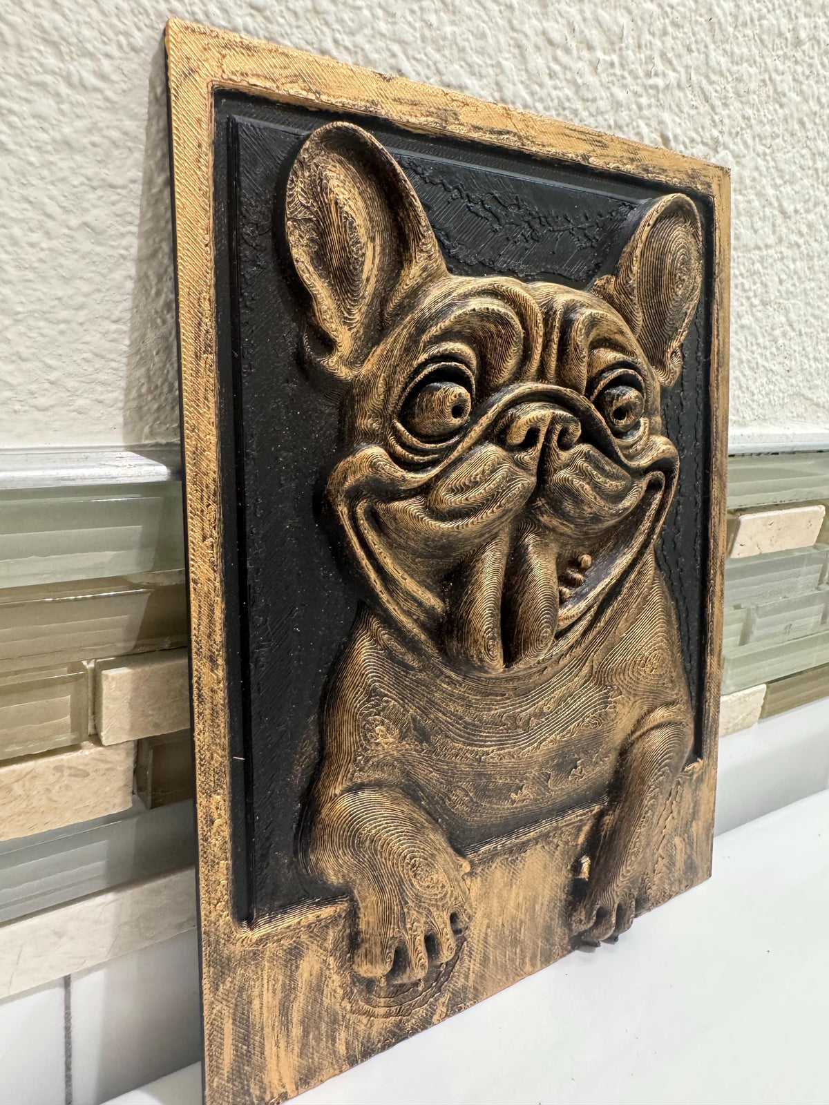 Right angle of the happy Frenchie plaque showing relief depth