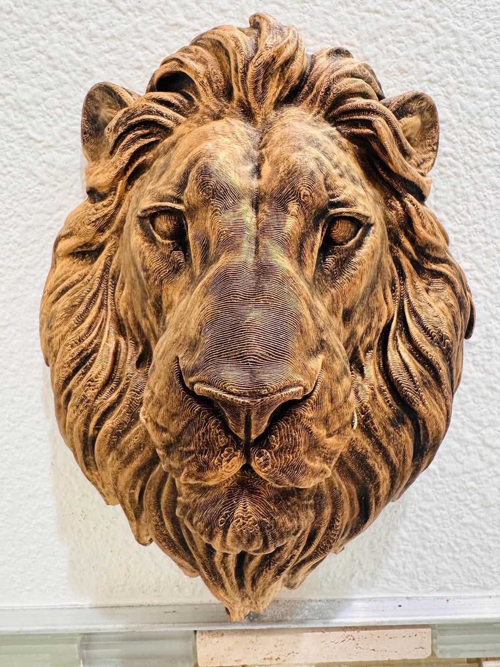 Close front view of the bronze lion's calm face and mane