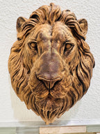 Close front view of the bronze lion's calm face and mane