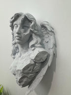 Left angle of the broken angel wall sculpture showing the fractured chest and wing