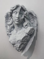 Front view of speckled gray broken angel bust with flowing hair and folded wings