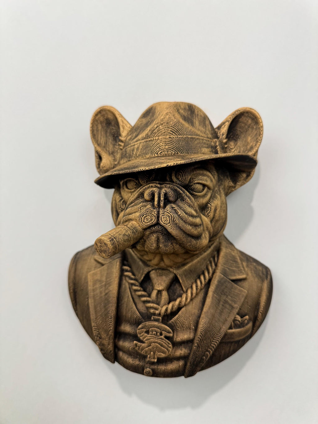 Front view of the gold French Bulldog mob boss on a white wall
