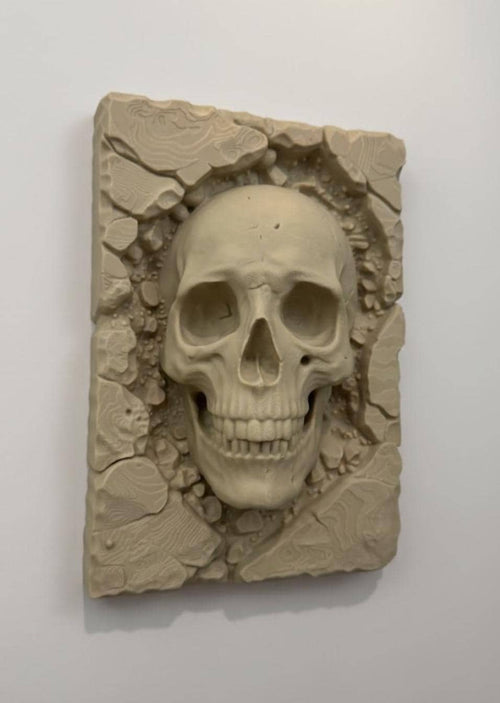 Slight angle of the skull relief plaque showing teeth and eye sockets