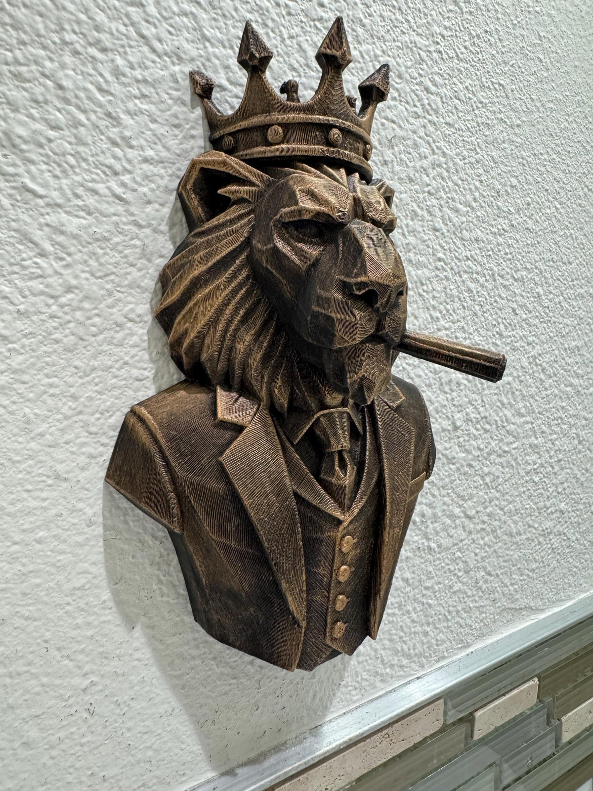 Left angle of the bronze lion boss showing cigar and mane facets