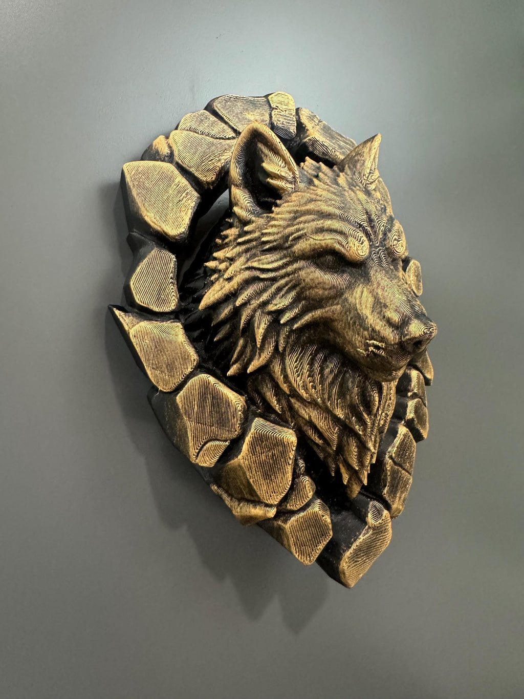 Right angle of the gold wolf head showing stone blocks and fur depth