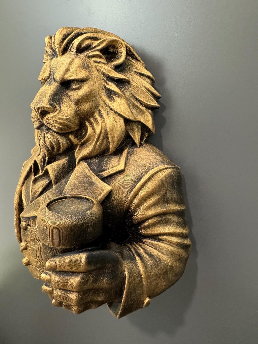 Left angle of the lion bust showing suit sleeve and beer glass