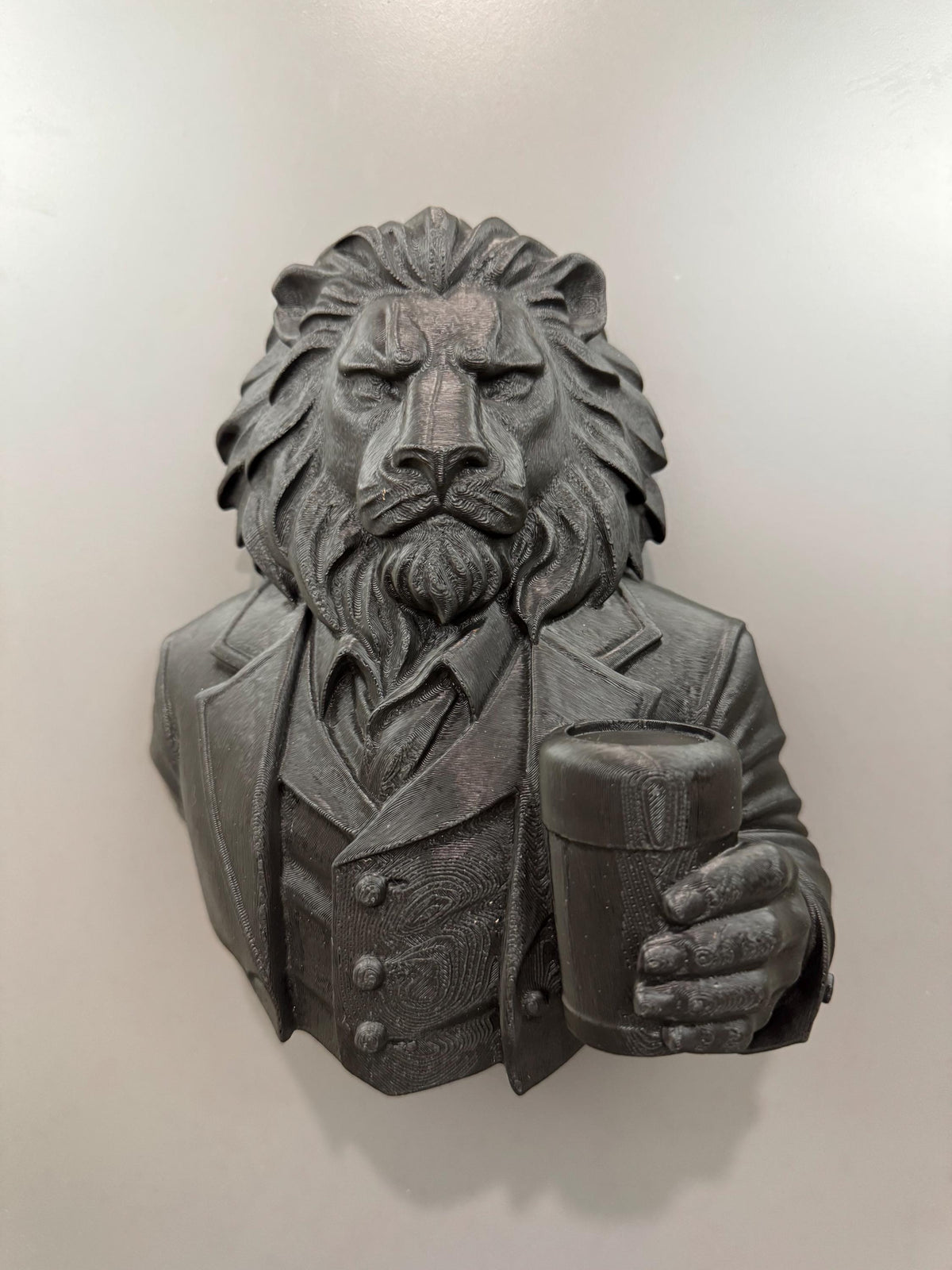 Front view of the black lion gentleman bust holding a beer glass