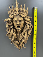 Crowned Medusa wall sculpture beside a tape measure showing its height