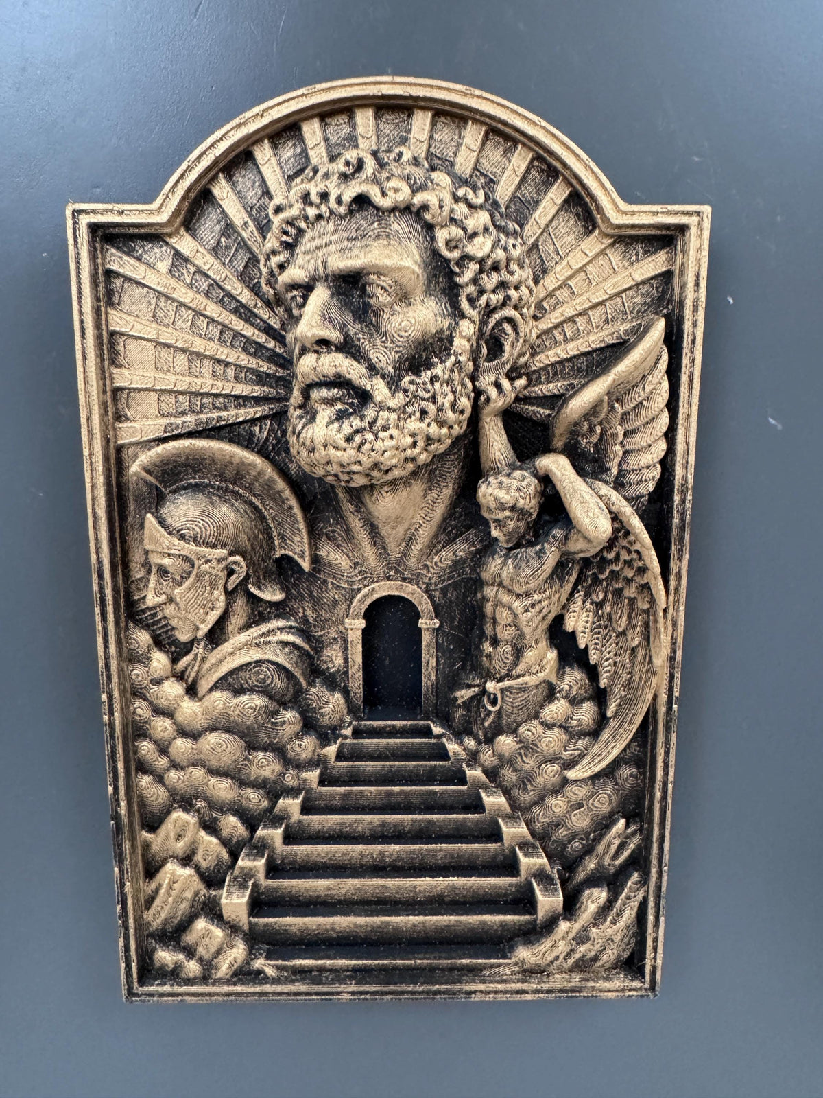 Front view of the Gates of Heaven plaque on a gray wall