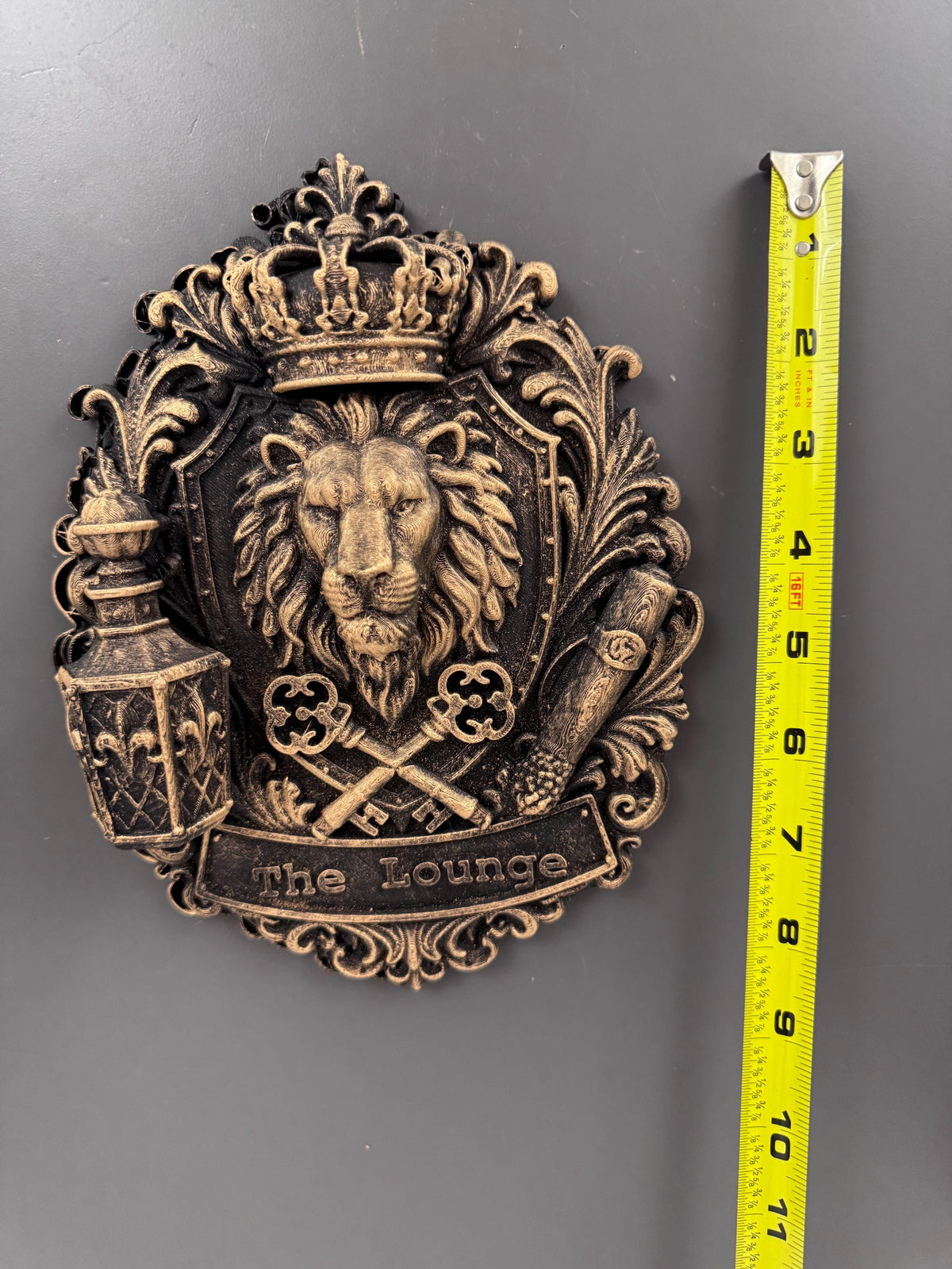 Lion crest plaque beside a tape measure showing its height