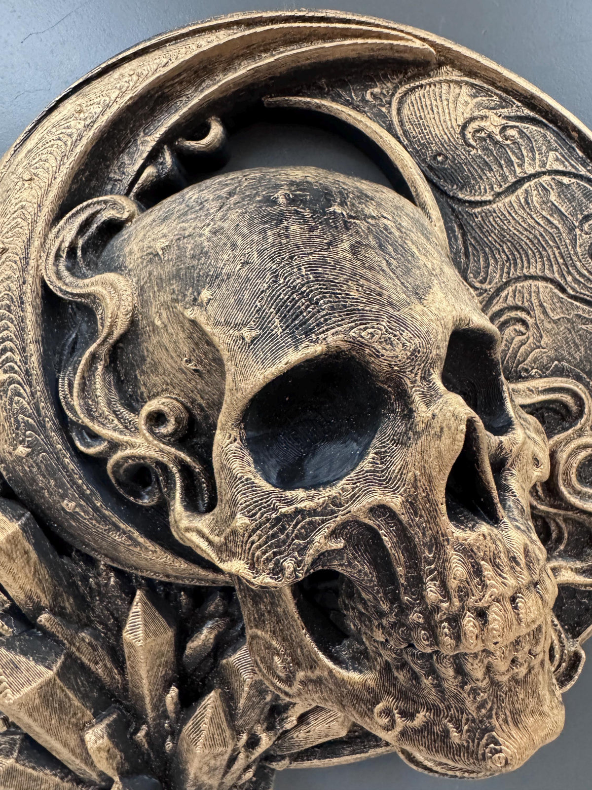 Close-up of the gold skull's eye sockets, teeth and etched stars