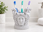 Speckled white Medusa toothbrush holder on a bathroom counter with three toothbrushes