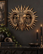 Ram sunburst sculpture on a dark wall above candles, books and a skull