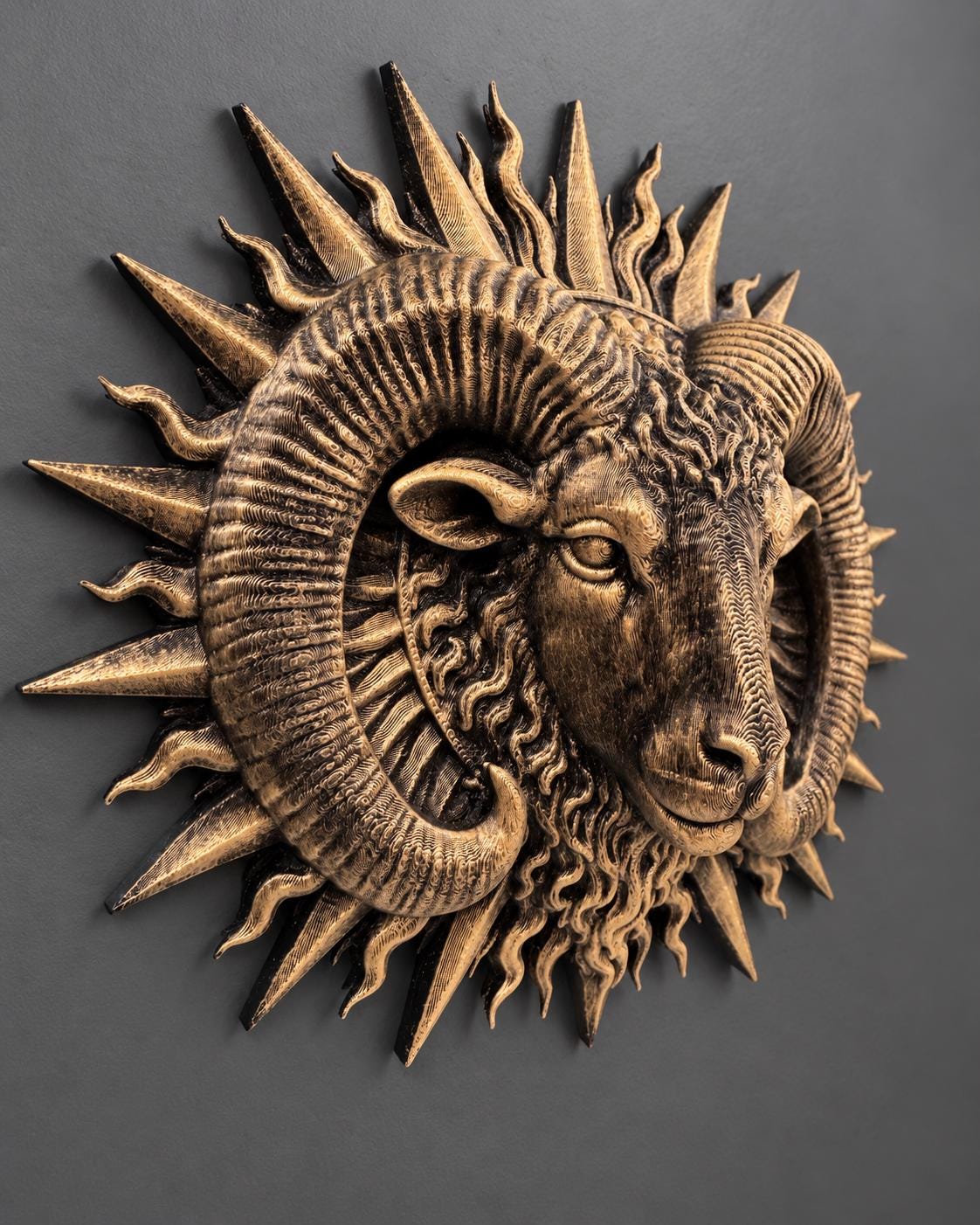 Right angle of the gold ram head showing horn ridges and sun rays