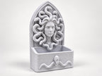 Angled view of the gothic Medusa wall organizer with an empty storage tray