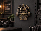 Grim reaper gym sculpture on a dark home gym wall beside weight plates