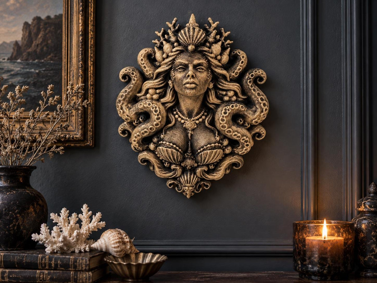 Siren Queen sculpture on a dark wall above coral, shells and a candle