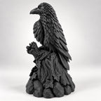 Side view of the raven figurine showing talons gripping the branch