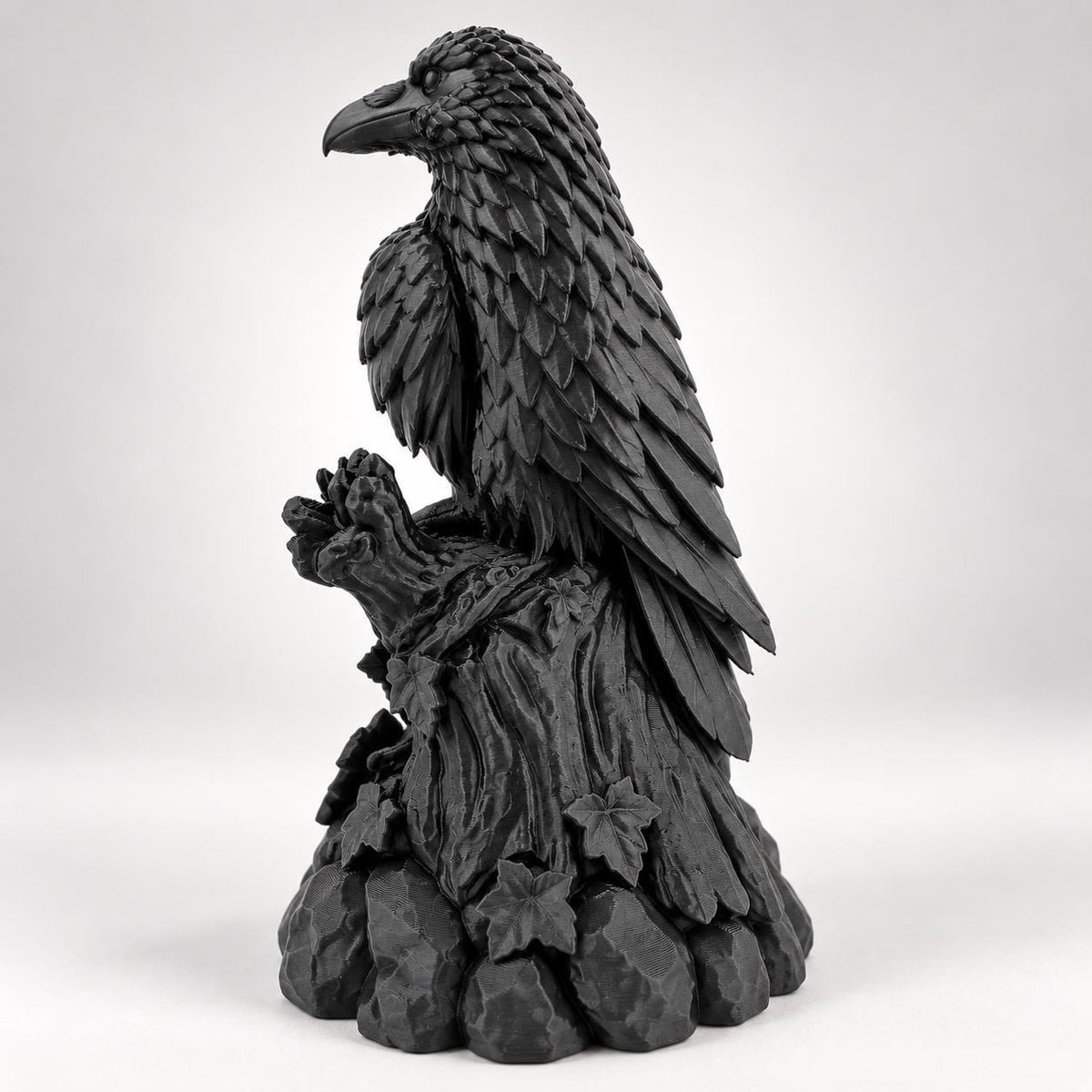 Side view of the raven figurine showing talons gripping the branch