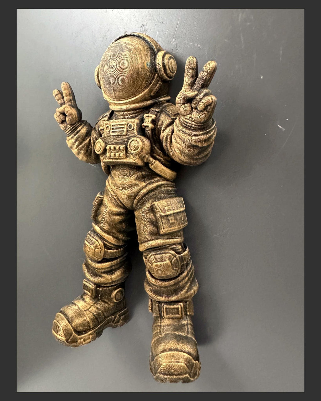 Right angle of the gold astronaut showing helmet and suit depth