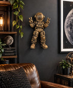 Peace sign astronaut sculpture hung in a living room beside a moon print