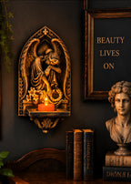 Angel tealight sconce on a dark wall beside books and a classical bust