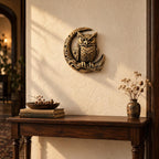 Owl and moon sculpture hung above a wooden console table