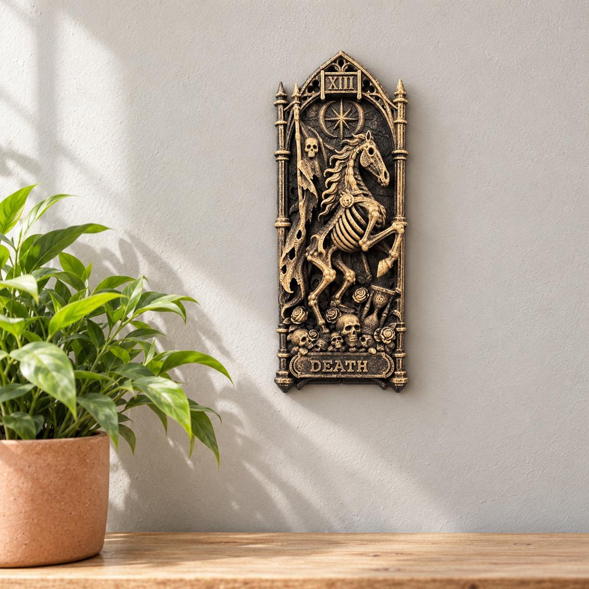 Death tarot wall relief hung beside a potted plant on a wooden shelf
