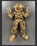 Front view of antique gold astronaut wall sculpture throwing peace signs with both hands