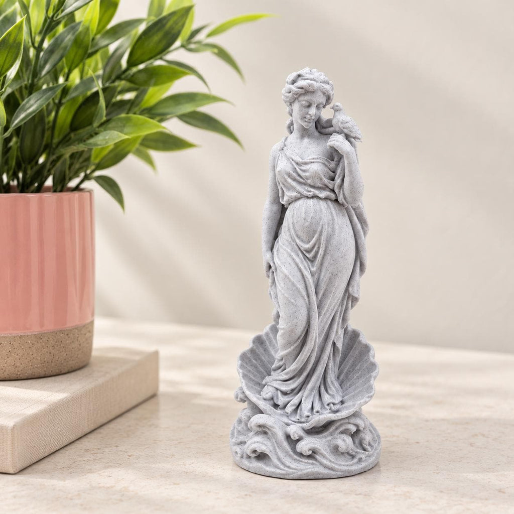 Aphrodite goddess statue standing above a sculpted wave base