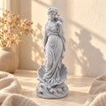 Pale speckled Aphrodite statue with a dove on her raised hand and scallop shell
