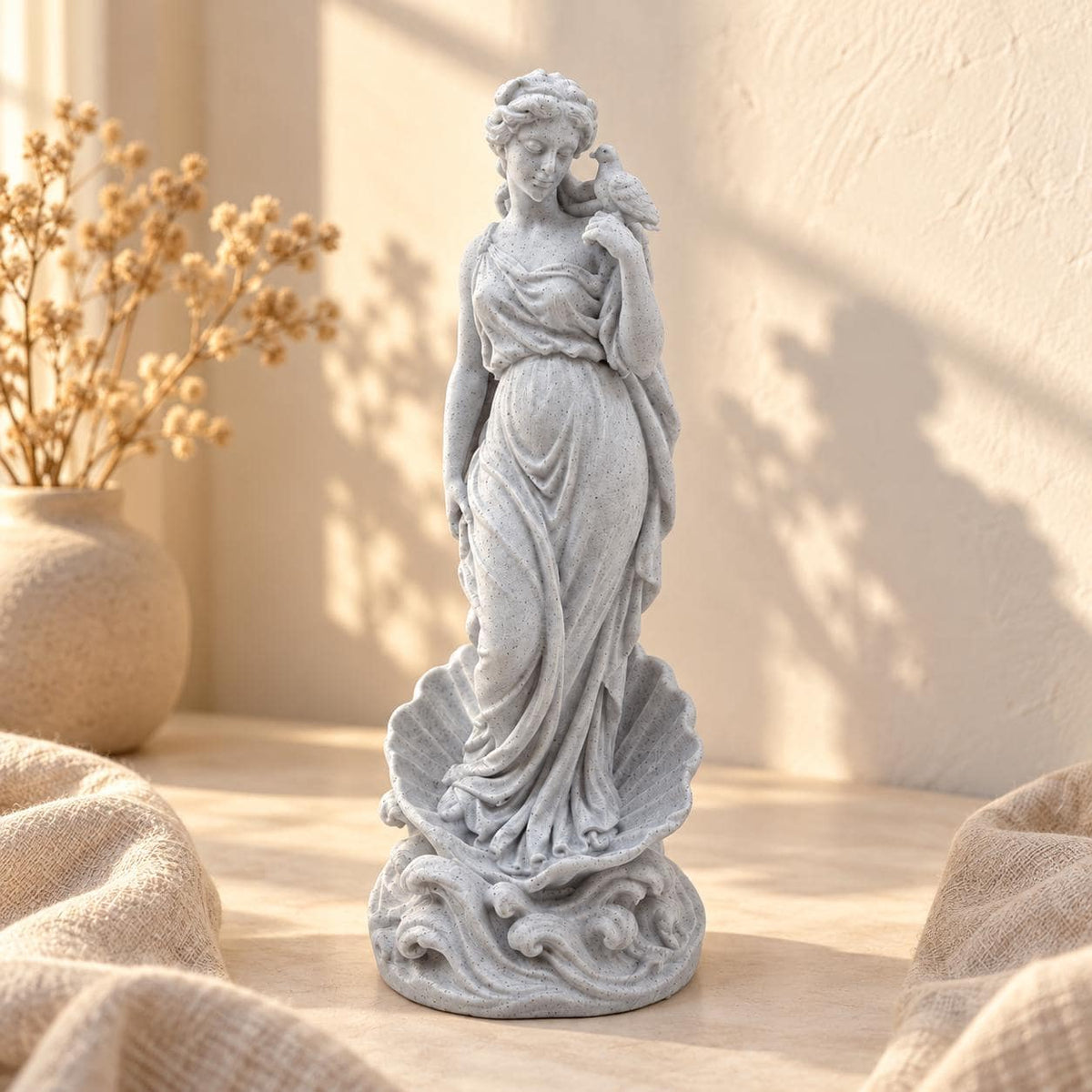 Pale speckled Aphrodite statue with a dove on her raised hand and scallop shell