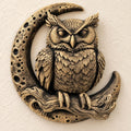 Front view of antique gold owl perched on a branch inside a cratered crescent moon