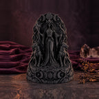 Front view of black Hecate statue with hounds on a dark red backdrop