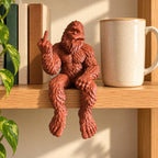 Bigfoot shelf sitter sitting on a shelf edge with legs hanging over
