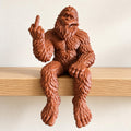 Reddish-brown Bigfoot shelf sitter figurine with a raised middle finger
