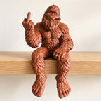 Reddish-brown Bigfoot shelf sitter figurine with a raised middle finger